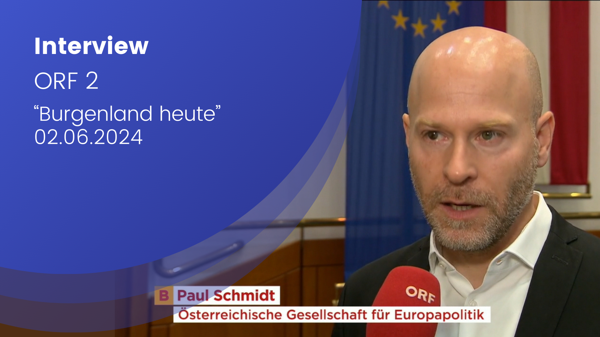 Paul Schmidt wird in einem Interview befragt. Im Hintergrund ist die EU Flagge und die Flagge Österreichs.